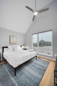 a white bedroom with a bed and a ceiling fan at Noble Nash - 8 Mins to Grand Ole Opry in Nashville