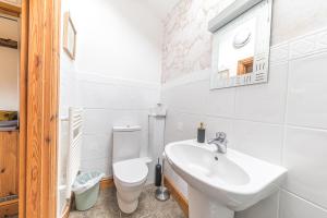 a white bathroom with a sink and a toilet at The Byre, Melmerby in Gamblesby