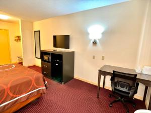 a hotel room with a bed and a desk with a computer at Super 8 by Wyndham Hillsville in Hillsville