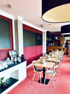 a row of tables and chairs in a restaurant at Hotel Brinckmansdorf in Rostock