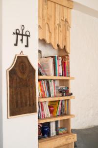 a book shelf with books and a cross on the wall at Riad Dar Sarah in Taghazout