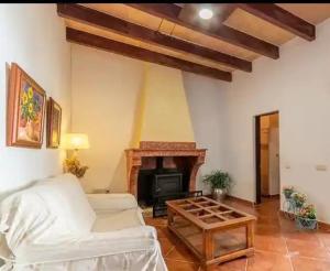 ein Wohnzimmer mit einer weißen Couch und einem Kamin in der Unterkunft Ca sa Cristeta de s'escola in Sa Pobla