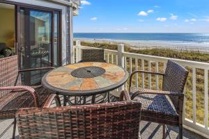 una mesa y sillas en un balcón con vistas a la playa en Sea Cloisters 305D Condo, en Myrtle Beach