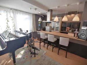 eine Küche mit einer Bar mit weißen Stühlen in der Unterkunft Lovely central flat with grand piano, family friendly in Berlin