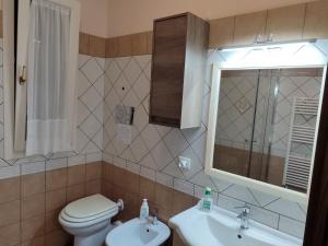 La salle de bains est pourvue de toilettes, d'un lavabo et d'un miroir. dans l'établissement LA MAISON DU PORT, à Licata