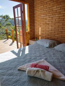 Postel nebo postele na pokoji v ubytování Casa Mohini Refúgio nas montanhas de Teresópolis Quarto com deck rede suspensa lareira cachoeira e piscina