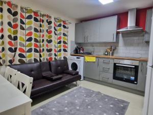 a kitchen with a couch in a small kitchen at Deluxe 1-Bed Apartment in Greenford in Greenford