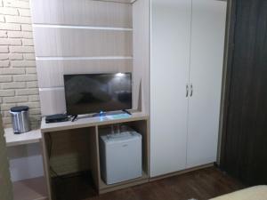a room with a tv and a desk with a computer at Hospedagem Vida e Natureza in Gramado