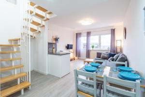 ein Wohnzimmer und eine Küche mit einem Esstisch und einer Treppe in der Unterkunft Ferienwohnung am Bug für 7 Gäste - Entspannung pur! #BugOase in Dranske