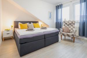 a bedroom with a large bed and a chair at Ferienwohnung am Bug für 7 Gäste - Entspannung pur! #BugOase in Dranske