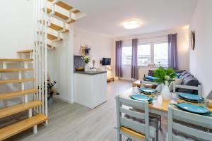 a dining room and living room with a table and chairs at Ferienwohnung am Bug für 7 Gäste - Entspannung pur! #BugOase in Dranske