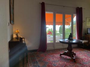 - un salon avec une table et une fenêtre dans l'établissement Villa à 350m des calanques Saint Aygulf, à Saint-Aygulf
