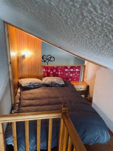 uma cama num quarto com uma parede de madeira em Appartement Plein Sud Cosy 6 personnes très bien équipé ,Vue splendide, Terrasse, Spacieux,Bien situé, Randonnées,Ski em Saint-Sorlin-dʼArves