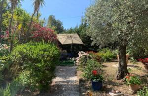 - un jardin avec une table et un parasol dans l'établissement Villa à 350m des calanques Saint Aygulf, à Saint-Aygulf