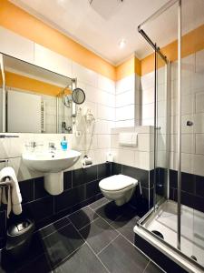 a bathroom with a sink and a toilet and a shower at Hotel Brinckmansdorf in Rostock +26 photos