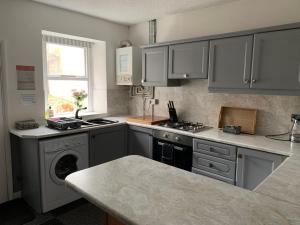 a kitchen with gray cabinets and a stove top oven at 16 Main Street in St Bees