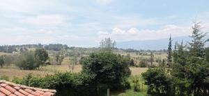 a view of a field with trees and mountains at El Encanto De La Villa Campestre in Villa de Leyva