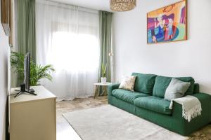 ヴェネツィアにあるPeggy's Houseのリビングルーム(緑のソファ、テレビ付)