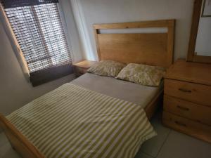 ein kleines Schlafzimmer mit einem Bett und einer Kommode in der Unterkunft Cozy 2 Bedroom Bungalow. in Freetown