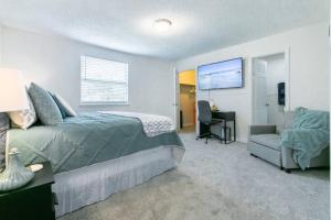 a bedroom with a bed and a couch and a chair at Fun 5* Hot Tub/Beaches getaway Near MAYO in Jacksonville