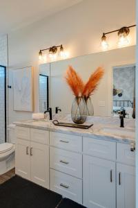 a bathroom with white cabinets and a vase with feathers in it at Nashville - 5631 Lenox Ave in Nashville