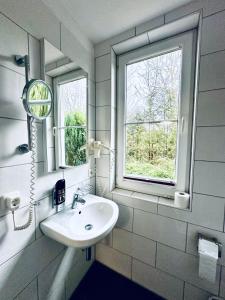 een badkamer met een wastafel en een raam bij Hotel Brinckmansdorf in Rostock