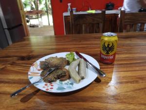 einen Teller mit Lebensmitteln auf einem Tisch mit einer Dose Soda in der Unterkunft Casa las pavas Bijagüa in Bijagua