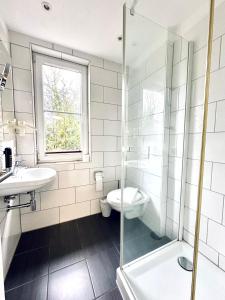 a bathroom with a toilet and a sink and a shower at Hotel Brinckmansdorf in Rostock +28 photos