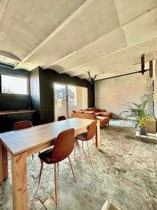 Habitación grande con mesa de madera y sillas. en Designer loft with sunny terrace, en Amberes