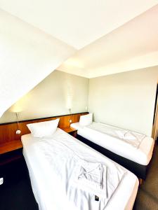 two beds in a hotel room with two bedsvisor at Hotel Brinckmansdorf in Rostock