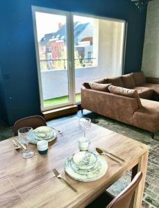 una mesa de madera con platos y vasos encima en Designer loft with sunny terrace, en Amberes
