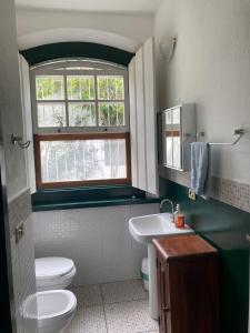 uma casa de banho com um WC, um lavatório e uma janela em CASA EM PARATY - EXCELENTE LOCALIZAÇÃO em Paraty