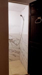 a shower with a hose in a bathroom at A room in a shared house for surfers2 in Safi