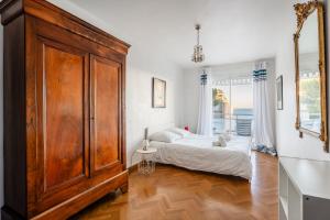 - une chambre avec un lit et une grande armoire en bois dans l'établissement Le Super Bestouan par Dodo à Cassis, à Cassis