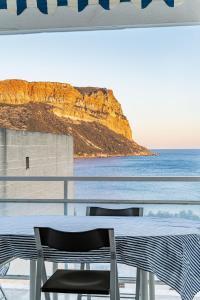 une table et des chaises sur un balcon avec vue sur l'océan dans l'établissement Le Super Bestouan par Dodo à Cassis, à Cassis