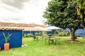 un patio con mesas, sillas y un árbol en Pancha Mama Hotel Boutique en Villa de Leyva