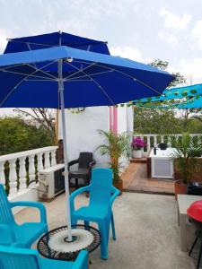 a blue umbrella and chairs on a patio at Cabaña Aldea Santorini in Doradal
