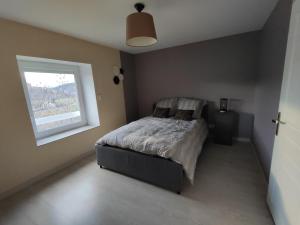 Schlafzimmer mit einem Bett und einem Fenster in der Unterkunft Maison vigneronne climatisée in Polignac