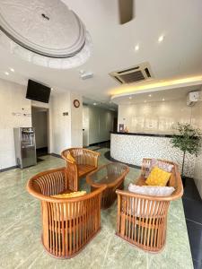 a lobby with chairs and a table and a counter at Swing & Pillows PJ Sunway Mentari formerly known as Swan Cottage Hotel in Petaling Jaya