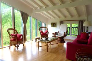 - un salon avec un canapé et des fauteuils rouges dans l'établissement Maison typique Basque en pleine campagne, à Saint-Pée-sur-Nivelle
