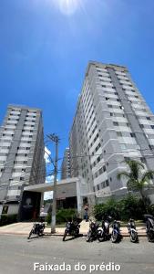 a group of motorcycles parked in front of two tall buildings at Apartamento 2 quartos completo com garagem in Juiz de Fora