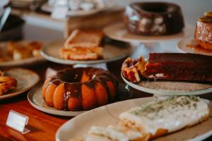 a table topped with plates of cakes and pastries at Hotel Chalé Capitólio in Capitólio