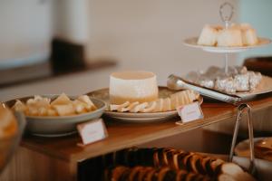 a table with cheese and other food items on it at Hotel Chalé Capitólio in Capitólio