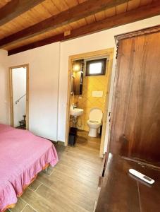 ein Schlafzimmer mit einem Bett und ein Badezimmer mit einem Waschbecken in der Unterkunft Casa le Maioliche by Housilia in Cefalú