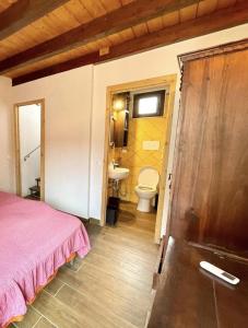 a bedroom with a bed and a bathroom with a sink at Casa le Maioliche by Housilia in Cefalù