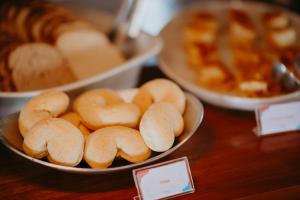 a table topped with bowls of bagels and bread at Hotel Chalé Capitólio in Capitólio