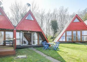 a house with a red roof and two blue chairs at Chalet Thirtysix in Deal