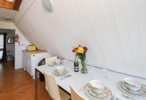 a white table with plates and a vase of flowers on it at Chalet Thirtysix in Deal +19 photos