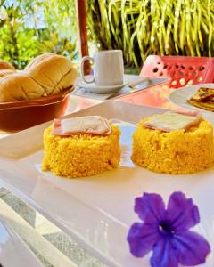 a plate with two slices of cake and a purple flower at Pousada Vida Sol in São Miguel dos Milagres