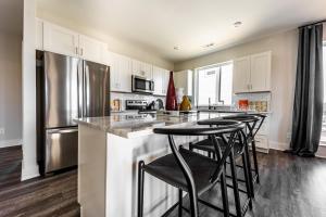 a kitchen with white cabinets and a stainless steel refrigerator at Nashville - 230 Oceola Ave in Nashville